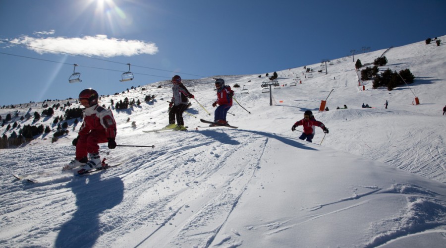 Esquiadors gaudint de les pistes, un dia molt solejat